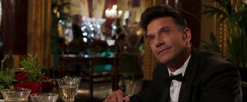 Movie still from “Lamborghini: The Man Behind the Legend” (2022), directed by Bobby Moresco – A man sitting at a table with a glass of wine; Close Up shot, Over the shoulder angle