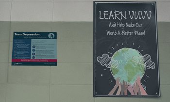 Movie still from “Landscape with Invisible Hand” (2023), directed by Cory Finley – A chalkboard sign with a picture of a globe on it; Extreme Close Up shot, Low angle
