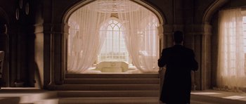 Movie still from “Lara Croft: Tomb Raider” (2001), directed by Simon West – A person standing in front of an open window; Wide shot, Low angle