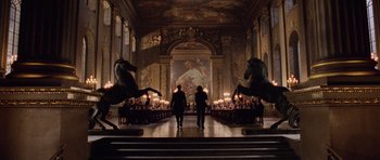 Movie still from “Lara Croft: Tomb Raider” (2001), directed by Simon West – Two people are walking down the hall of a building; Extreme Wide shot, Low angle