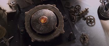 Movie still from “Lara Croft: Tomb Raider” (2001), directed by Simon West – An ornate metal object sitting on top of a table; Extreme Close Up shot, Overhead angle