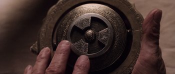 Movie still from “Lara Croft: Tomb Raider” (2001), directed by Simon West – A hand is holding an object in front of it; Extreme Close Up shot, Overhead angle