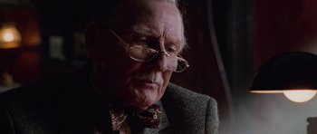 Movie still from “Lara Croft: Tomb Raider” (2001), directed by Simon West – An old man wearing glasses and a bow tie; Close Up shot, Low angle