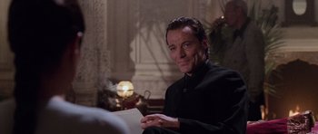 Movie still from “Lara Croft: Tomb Raider” (2001), directed by Simon West – A man sitting in front of a fireplace holding an envelope; Close Up shot, Over the shoulder angle