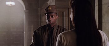 Movie still from “Lara Croft: Tomb Raider” (2001), directed by Simon West – A man wearing a hat standing next to a woman; Close Up shot, Over the shoulder angle