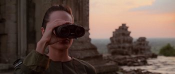 Movie still from “Lara Croft: Tomb Raider” (2001), directed by Simon West – A man looking through a pair of binoculars; Close Up shot, Over the shoulder angle