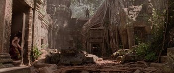 Movie still from “Lara Croft: Tomb Raider” (2001), directed by Simon West – A man standing on top of an old stone building; Extreme Wide shot, Low angle