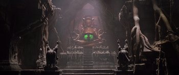 Movie still from “Lara Croft: Tomb Raider” (2001), directed by Simon West – A large statue of a buddha in the middle of a room; Wide shot, High angle