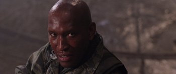 Movie still from “Lara Croft: Tomb Raider” (2001), directed by Simon West – A man with a bald head is looking at the camera; Close Up shot, Low angle