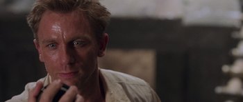 Movie still from “Lara Croft: Tomb Raider” (2001), directed by Simon West – A person sitting down with his hand under his chin; Close Up shot, High angle