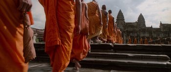 Movie still from “Lara Croft: Tomb Raider” (2001), directed by Simon West – A group of monks walking down steps in orange robes; Wide shot, Low angle
