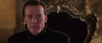 Movie still from “Lara Croft: Tomb Raider” (2001), directed by Simon West – A person wearing a suit and tie; Close Up shot, Low angle