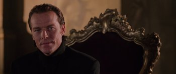 Movie still from “Lara Croft: Tomb Raider” (2001), directed by Simon West – A person sitting in front of a chair; Close Up shot, Over the shoulder angle