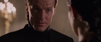 Movie still from “Lara Croft: Tomb Raider” (2001), directed by Simon West – A person wearing a suit and tie; Close Up shot, Over the shoulder angle