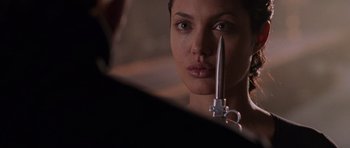 Movie still from “Lara Croft: Tomb Raider” (2001), directed by Simon West – A person holding a knife in their face; Close Up shot, Over the shoulder angle