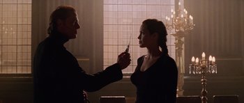 Movie still from “Lara Croft: Tomb Raider” (2001), directed by Simon West – A man and a woman holding a pair of knifes; Medium shot, Low angle