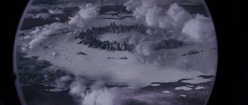 Movie still from “Lara Croft: Tomb Raider” (2001), directed by Simon West – An aerial view of a mountain range covered in clouds; Extreme Wide shot, Overhead angle
