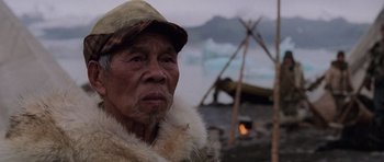 Movie still from “Lara Croft: Tomb Raider” (2001), directed by Simon West – An older man wearing a fur coat and a hat; Close Up shot, Low angle