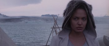 Movie still from “Lara Croft: Tomb Raider” (2001), directed by Simon West – A woman in a fur hat standing in front of a body of water; Close Up shot, Over the shoulder angle