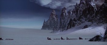 Movie still from “Lara Croft: Tomb Raider” (2001), directed by Simon West – A group of people on a snow covered field; Extreme Wide shot, High angle