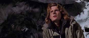 Movie still from “Lara Croft: Tomb Raider” (2001), directed by Simon West – A man with long blonde hair looking up at the sky; Close Up shot, Low angle