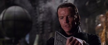 Movie still from “Lara Croft: Tomb Raider” (2001), directed by Simon West – A person holding something in his hand; Close Up shot, Over the shoulder angle