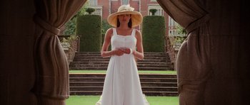 Movie still from “Lara Croft: Tomb Raider” (2001), directed by Simon West – A woman wearing a white dress and a hat; Medium shot, Low angle