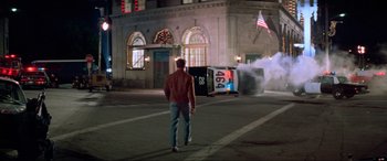 Movie still from “Last Action Hero” (1993), directed by John McTiernan – A man walking on the street near a fire truck; Wide shot, Over the shoulder angle
