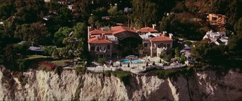 Movie still from “Last Action Hero” (1993), directed by John McTiernan – An aerial view of a house on a cliff; Extreme Wide shot, High angle