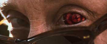 Movie still from “Last Action Hero” (1993), directed by John McTiernan – A person's eye with a glass in front of it; Extreme Close Up shot, Overhead angle