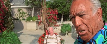 Movie still from “Last Action Hero” (1993), directed by John McTiernan – An old man tied to a chair in front of another man; Close Up shot, Low angle