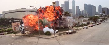 Movie still from “Last Action Hero” (1993), directed by John McTiernan – An explosion is seen in the background of this picture; Extreme Wide shot, High angle