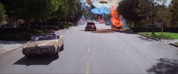 Movie still from “Last Action Hero” (1993), directed by John McTiernan – A car that is on fire in the street; Extreme Wide shot, High angle