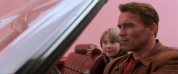 Movie still from “Last Action Hero” (1993), directed by John McTiernan – A man and a woman sitting in a car looking out the window; Close Up shot, Low angle
