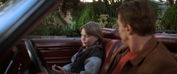 Movie still from “Last Action Hero” (1993), directed by John McTiernan – A boy sitting in a car with another boy; Medium shot, Over the shoulder angle