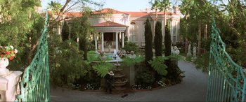 Movie still from “Last Action Hero” (1993), directed by John McTiernan – A man in a cowboy hat is sweeping the sidewalk; Extreme Wide shot, High angle