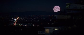 Movie still from “Last Action Hero” (1993), directed by John McTiernan – A full moon rises over a city at night; Extreme Wide shot, High angle