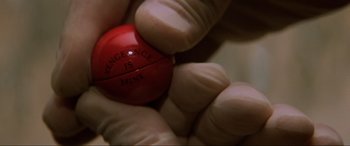Movie still from “Last Action Hero” (1993), directed by John McTiernan – A person holding a small red ball in their hand; Extreme Close Up shot, High angle