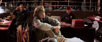 Movie still from “Last Action Hero” (1993), directed by John McTiernan – A man sitting on the floor next to another man; Medium shot, Low angle