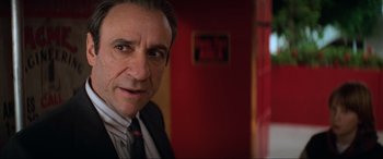 Movie still from “Last Action Hero” (1993), directed by John McTiernan – A person wearing a suit and tie; Close Up shot, Over the shoulder angle