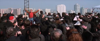 Movie still from “Last Action Hero” (1993), directed by John McTiernan – A crowd of people holding guns in the air; Wide shot, Overhead angle