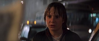 Movie still from “Last Action Hero” (1993), directed by John McTiernan – A young man with wet hair looking at the camera; Close Up shot, Over the shoulder angle