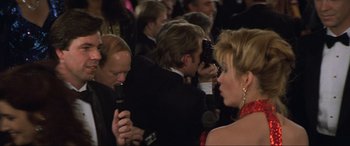 Movie still from “Last Action Hero” (1993), directed by John McTiernan – A man and a woman are being interviewed by a camera man; Close Up shot, Over the shoulder angle