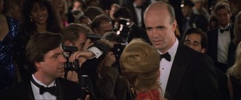 Movie still from “Last Action Hero” (1993), directed by John McTiernan – A man in a tuxedo is surrounded by a crowd of onlookers; Close Up shot, Over the shoulder angle