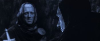 Movie still from “Last Action Hero” (1993), directed by John McTiernan – A man in a hooded jacket looking at another man in a hooded jacket; Close Up shot, Over the shoulder angle