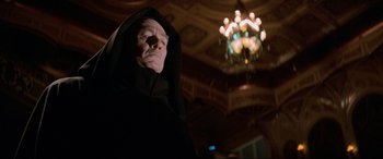Movie still from “Last Action Hero” (1993), directed by John McTiernan – An old man in a black robe and a chandelier; Medium shot, Low angle