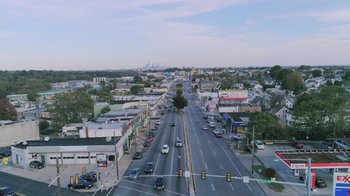 Movie still from “Last Call” (2021), directed by Paolo Pilladi – An aerial view of a street with cars driving down it; Extreme Wide shot, High angle