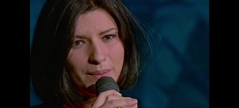Movie still from “Laura Pausini: Pleasure to Meet You” (2022), directed by Ivan Cotroneo – A person holding a microphone; Extreme Close Up shot, High angle
