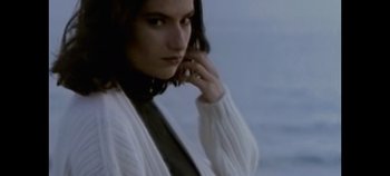 Movie still from “Laura Pausini: Pleasure to Meet You” (2022), directed by Ivan Cotroneo – A woman in a white sweater talking on a cell phone; Close Up shot, Low angle