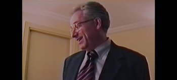 Movie still from “Laura Pausini: Pleasure to Meet You” (2022), directed by Ivan Cotroneo – An older man wearing a suit and tie; Close Up shot, High angle